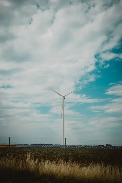 A vertical shot of industrial wind turbines on a rural field