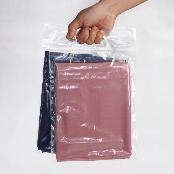 Hand Som Håller Rosa Och Mörkblå Tyger Plastförpackningar — Stockfoto