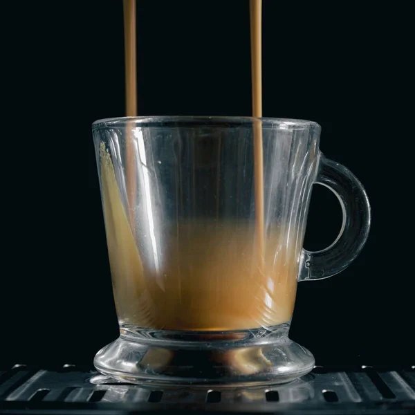マシンからカップに注ぐコーヒーの2つのスプレーのクローズアップショット — ストック写真