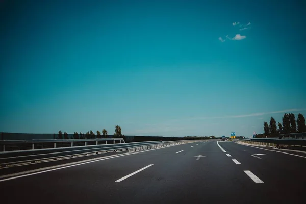 Een Geasfalteerde Weg Met Witte Markeringen Leuningen Onder Een Blauwe — Stockfoto