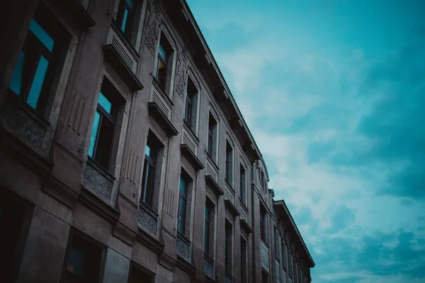 Низькокутний Знімок Коричневої Будівлі Вікнами Тлом Блакитного Вечірнього Неба — стокове фото