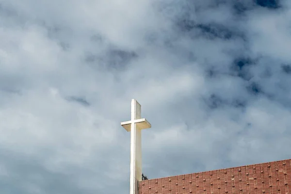 在蓝天蓝云的背景下 在教堂顶部的一个白色十字架的特写镜头 — 图库照片