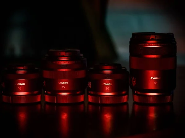 Närbild Olika Stora Kameralinser Ett Bord Rött Ljus — Stockfoto