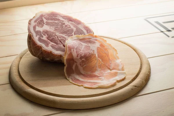 用木盘上铺着一片美味的意大利面色拉米 — 图库照片
