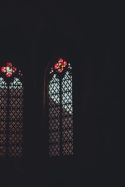 彩色彩色玻璃在黑暗中在教堂里印刷的彩色玻璃的垂直截图 — 图库照片