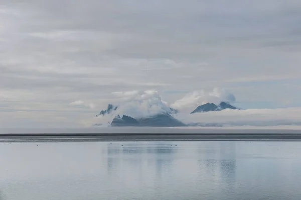 雲の中に岩の上にアイスランドの南東海岸のビーチからの眺め — ストック写真