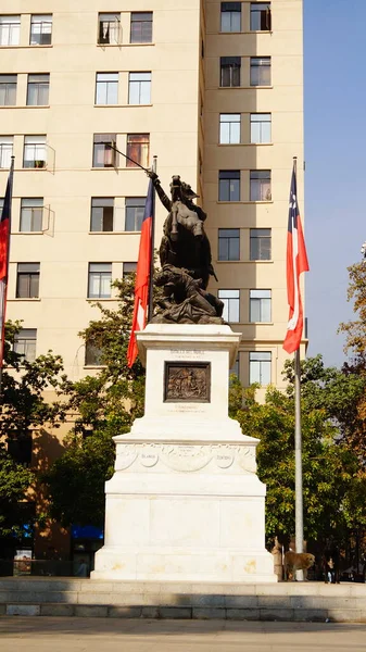 Вертикальный Снимок Статуи Самца Лошади Возле Флагов Чили — стоковое фото