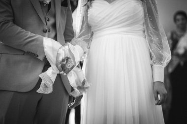 Gelin ve damadın düğün törenindeki gri tonlu resmi.