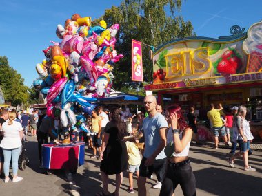 Güneşli bir günde Almanya 'da düzenlenen Ren Balığı Festivali sırasında insanlarla dolu bir lunapark.