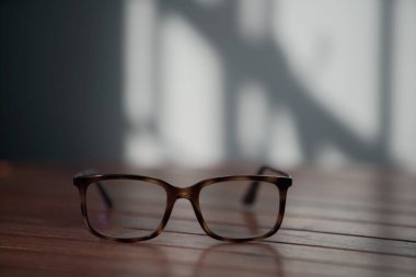 Ahşap bir masanın üzerindeki optik gözlüklerin yakın çekimi.