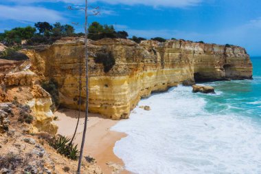 Praia da Marinha ve Portekiz 'deki keskin uçurumlarının manzaralı bir çekimi.