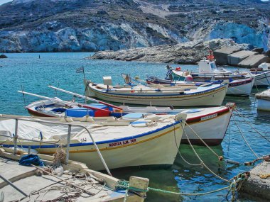 A small harbor with fishing boats and crystal clear turquoise waters in Mandrakia village in Milos island, Greece