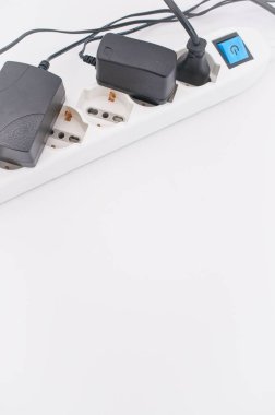 Elektrik kablosu ve şarj aletleri kopyalama alanı olan beyaz bir masada.