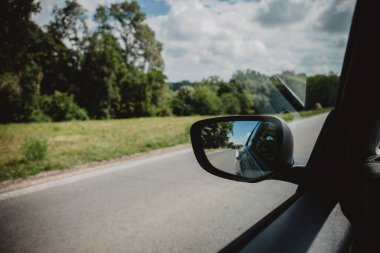 Bir asfalt yol ve ormanların gündüz vakti bir arabadan görünüşü