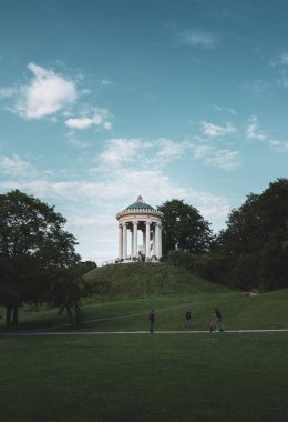 Monopteros 'un Münih' te güneşli bir gökyüzünün altında dikey bir görüntüsü.