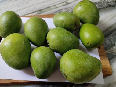 Kesme tahtasındaki olgunlaşmamış yeşil mangolar