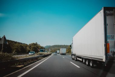 Viyana, Avusturya 'da karayolu trafiği mavi gökyüzü arka planı, yolun karşısındaki ağaçlar ve caddedeki arabalar