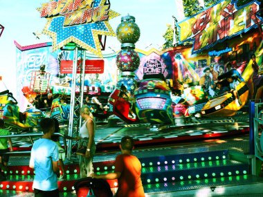 Güneşli bir günde Almanya 'da düzenlenen Ren Balığı Festivali sırasında insanlarla dolu bir lunapark.