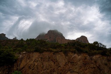 Bulutlu bir günde Esterel Massif dağlarının eteklerindeki kayalıkların harika manzarası.