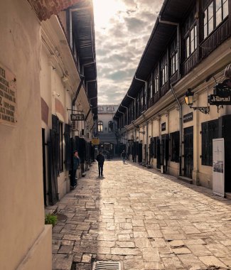 Romanya 'nın Bükreş şehir merkezindeki Hanul cu Tei caddesinde eski binalar arasında kaldırımlı bir ara sokak bulunuyor.
