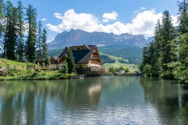 İtalya 'nın Alta Val Badia şehrinde küçük bir evi ve dağları olan güzel Sompunt Gölü.
