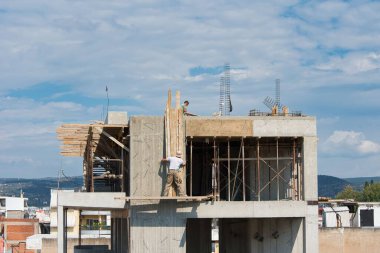 İnşaat alanı, çok katlı bina inşaatı için tehlikeli işlerde çalışan işçiler.