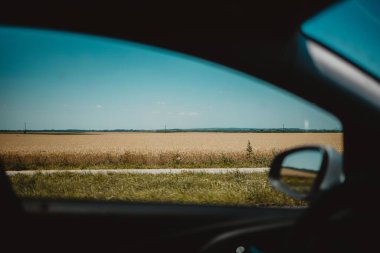 Bir araba penceresinden tarlaların görünümü