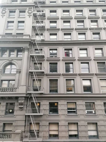 窓とテクスチャの建物のファサードの垂直ショット — ストック写真