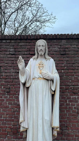 Plano Vertical Una Estatua Mármol Blanco Jesucristo Contra Pared Ladrillo —  Fotos de Stock