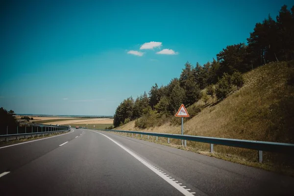 Ένας Αυτοκινητόδρομος Λευκά Σημάδια Πινακίδες Κάγκελα Και Πράσινα Δέντρα Δίπλα — Φωτογραφία Αρχείου