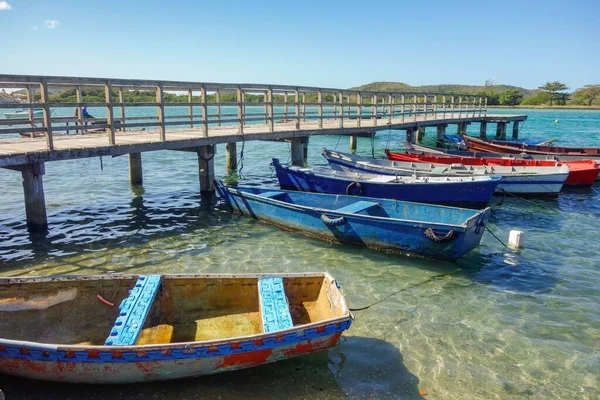 wooden fishing rafts moored beside a deck on tropical beach.