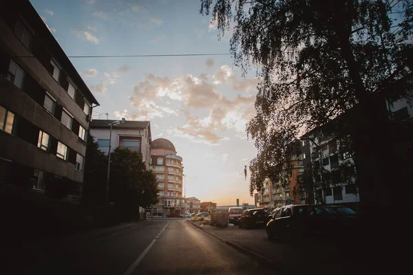 Eine Stadtstraße Mit Gebäuden Auf Beiden Seiten Bei Sonnenuntergang — Stockfoto