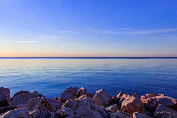 Turuncu Günbatımında Berrak Bir Denizin Kıyısındaki Kayaların Güzel Manzarası — Stok fotoğraf