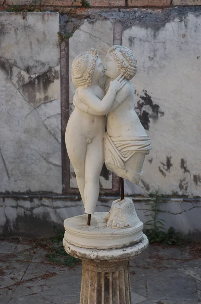 A vertical shot of a sculpture of kissing cupid and psyche in the street in Rome Italy