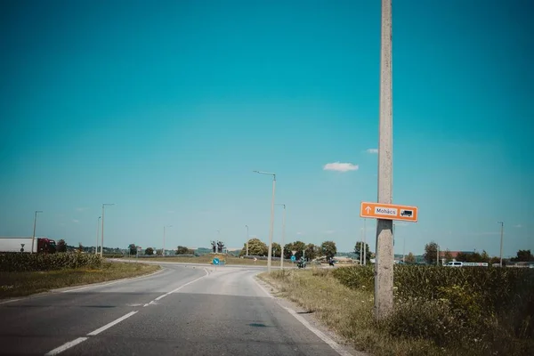 Eine Lange Asphaltstraße Durch Ein Ländliches Feld Unter Blauem Himmel — Stockfoto