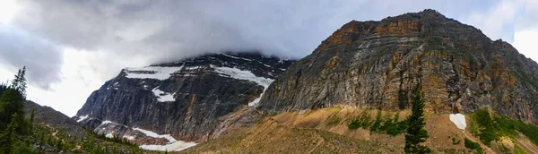 Panoramaaufnahme Eines Felsigen Berges Mit Wenig Schnee Und Wolken Die — Stockfoto