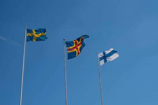Снимок Низкого Угла Размахивания Флагами Швеции Аланда Финляндии Фоне Голубого — стоковое фото