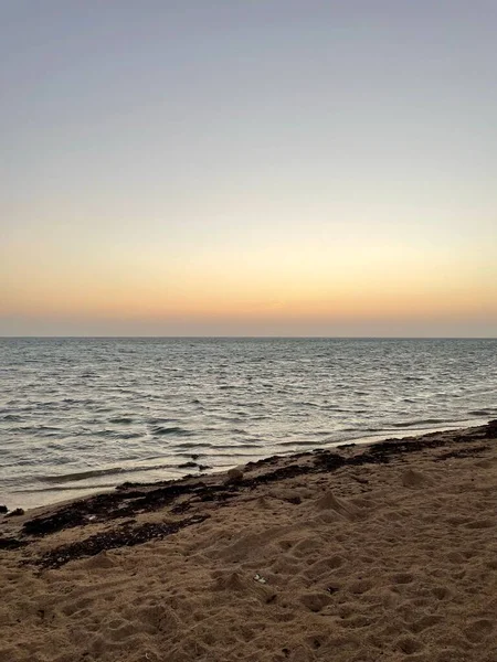 波と砂のビーチと青い海の美しい夕日 — ストック写真