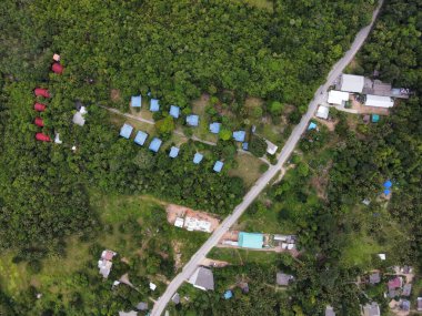 Tayland 'daki Koh Phangan adasının yeşil ormanlarındaki otellerin havadan görünüşü.