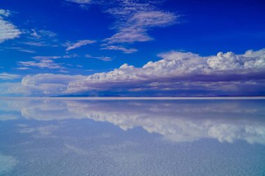 Uyuni Salt Flat 'in arka planda bulutlu gündüz görüntüsü.
