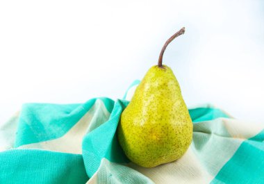 Beyaz arka planı olan bir havlunun üzerindeki armudun yakın plan çekimi.