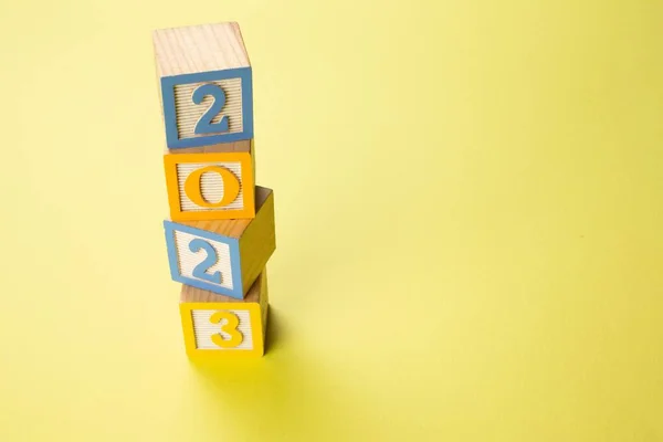Kleurrijke Houten Blokjes Gestapeld Elkaar Spelling 2023 Geïsoleerd Gele Achtergrond — Stockfoto