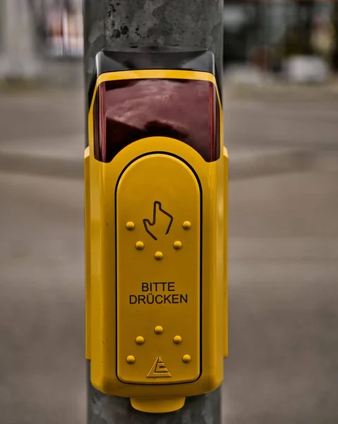 A yellow traffic light call button