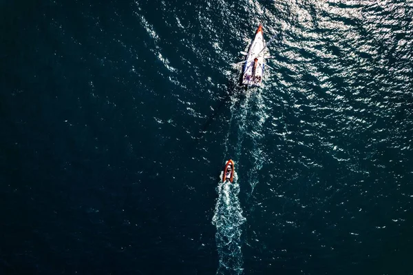 深い青色の海に小さなボートをドラッグヨットの空中トップビュー — ストック写真