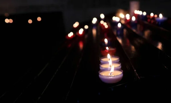 黑暗中一排点亮的蜡烛的特写镜头 — 图库照片