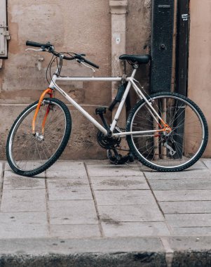 Bir binanın yanındaki kaldırıma park edilmiş modern beyaz bir bisiklet.