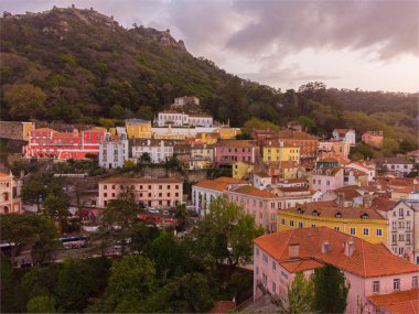 Sintra şehrinin yüksek açılı görüntüsü. Gün batımında vadide renkli binalar var.