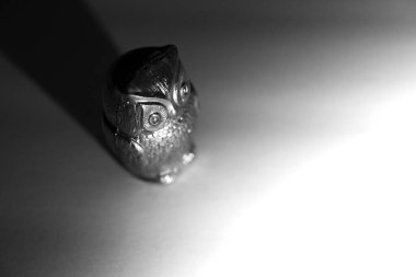 Bir baykuşun gölgesi olan tuzluk şeklindeki gri tonlu görüntüsü.