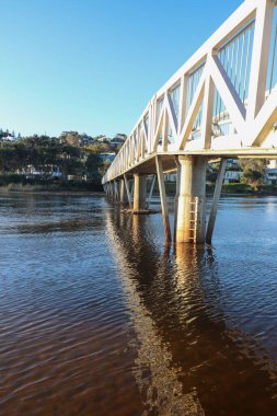 Gerroa Güney Kıyısı NSW Avustralya 'daki Eğri Nehir üzerinde modern bir yaya köprüsü.