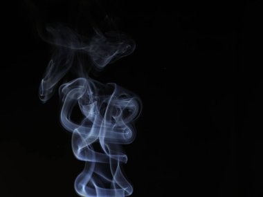 Siyah arkaplanda soyut beyaz duman hareketinin yakın çekimi